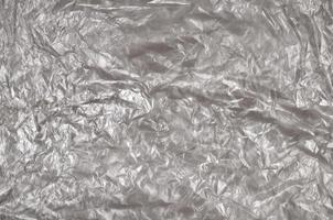 Texture of white crumpled cellophane surface transparent on sunlight. Concept of materials for packaging, product protection against damage photo