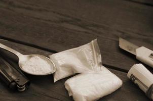 Lighter and spoon full of white powder on wooden background. Heroin drug addiction concept photo