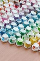 A pattern from a many nozzles from a paint sprayer for drawing graffiti, smeared into different colors. The plastic caps are arranged in many rows forming the color of the rainbow photo