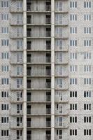 Textured pattern of a russian whitestone residential house building wall with many windows and balcony under construction photo