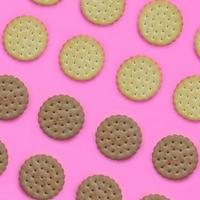 Pattern of a brown biscuits on a pink background. Trendy minimal concept of food and dessert. Abstract flat lay, top view photo