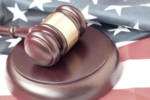 Justice mallet on United States flag in a courtroom during a judicial trial. Law concept and empty copyspace. Judge hammer photo