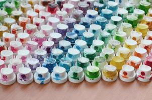 A pattern from a many nozzles from a paint sprayer for drawing graffiti, smeared into different colors. The plastic caps are arranged in many rows forming the color of the rainbow photo