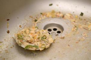 Close up on dirty clogging kitchen sink drain with food particles photo