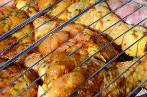 Marinated chicken legs on hot BBQ charcoal field grill photo