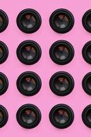 A few camera lenses with a closed aperture lie on texture background of fashion pastel pink color paper in minimal concept. Abstract trendy pattern photo