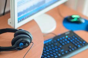 Big black headphones lie on the wooden desktop of the sound designer photo