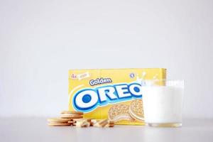 TERNOPIL, UKRAINE - MAY 28, 2022 Oreo golden crispy cookies with glass of milk on white background. The brand Oreo is owned by company Mondelez international photo