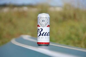 sumy, ucrania - 01 de agosto de 2022 lata de cerveza de alcohol budweiser lager en un bote de kayak volcado al aire libre. budweiser es una marca de anheuser-busch inbev foto