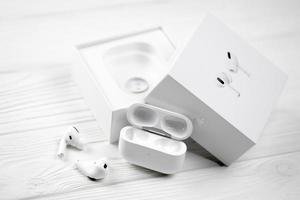 KHARKIV, UKRAINE - JANUARY 27, 2022 Apple AirPods Pro on a white background. Wireless headphones with charging case and a box. Apple Inc. is an American technology company photo