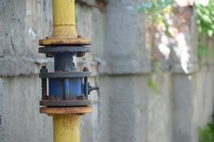 Yellow gas pipe in front of residential building wall photo