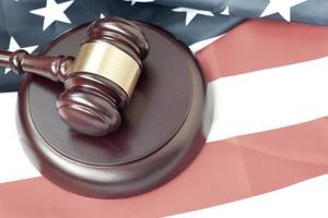 Justice mallet on United States flag in a courtroom during a judicial trial. Law concept and empty copyspace. Judge hammer photo