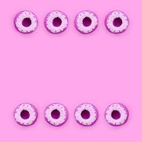Many small plastic donuts lies on a pastel colorful background. Flat lay minimal pattern. Top view photo