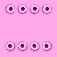 Many small plastic donuts lies on a pastel colorful background. Flat lay minimal pattern. Top view photo