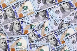 A large number of US dollar bills of a new design with a blue stripe in the middle. Top view photo