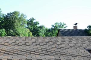 Modern roofing and decoration of chimneys. Flexible bitumen or slate shingles photo