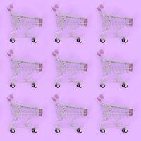Shopping addiction, shopping lover or shopaholic concept. Many small empty shopping carts perform a pattern on a pastel colored paper background. Flat lay composition, top view photo