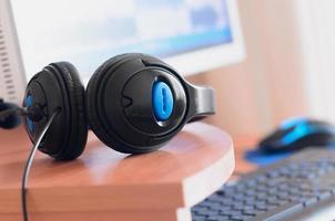 Big black headphones lie on the wooden desktop of the sound designer photo