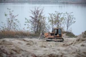 Quarry aggregate with heavy duty machinery. Caterpillar loader Excavator with backhoe driving to construction site quarry photo