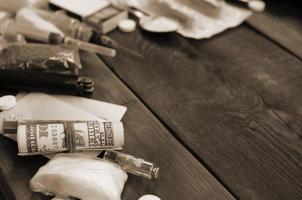 A lot of narcotic substances and devices for the preparation of drugs lie on an old wooden table photo