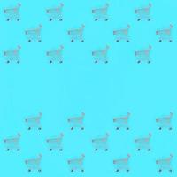 Shopping addiction, shopping lover or shopaholic concept. Many small empty shopping carts perform a pattern on a pastel colored paper background. Flat lay composition, top view photo