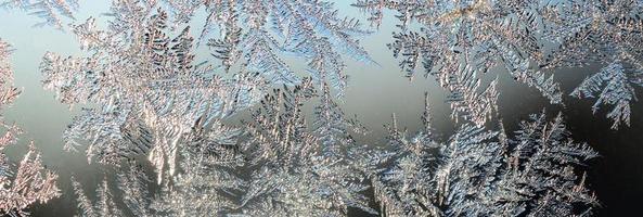 Snowflakes frost rime macro on window glass pane photo