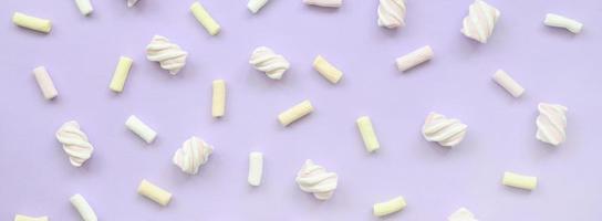 Colorful marshmallow laid out on violet paper background. pastel creative texture. minimal photo