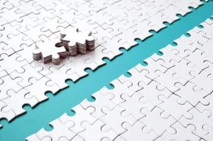 The blue path is laid on the platform of a white folded jigsaw puzzle. The missing elements of the puzzle are stacked nearby. Texture image with space for text photo