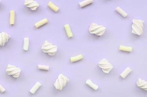 Colorful marshmallow laid out on violet paper background. pastel creative texture. minimal photo