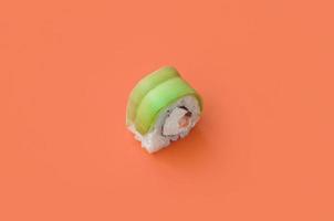 Vegetarian sushi roll with avocado and philadelphia cheese on orange background. Minimalism top view flat lay with Japanese food photo