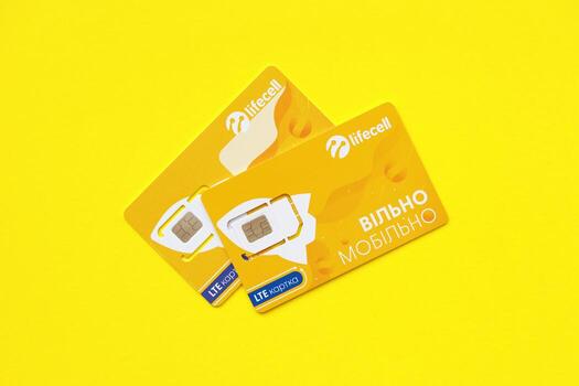 TERNOPIL, UKRAINE - JULY 5, 2022 Lifecell new sim card with free contract on yellow background. Lifecell is ukrainian mobile telephone network operator and provider of wireless connection photo