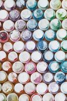 A pattern from a many nozzles from a paint sprayer for drawing graffiti, smeared into different colors. The plastic caps are arranged in many rows forming the color of the rainbow photo