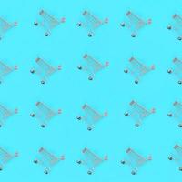 Shopping addiction, shopping lover or shopaholic concept. Many small empty shopping carts perform a pattern on a pastel colored paper background. Flat lay composition, top view photo