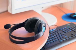 Big black headphones lie on the wooden desktop of the sound designer photo