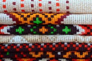 Stack of traditional Ukrainian folk art knitted embroidery patterns on textile fabric photo