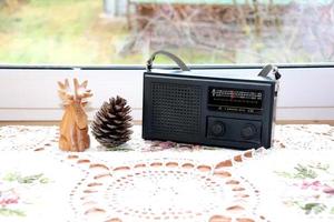 old radio on a knitted napkin near window photo
