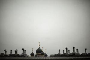 Roof of house and Orthodox cross. View of roof in city. Russian city in detail. Pipes on building. photo