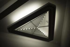 Triangular light source. Lamp in interior. Designer light. Architecture details. photo