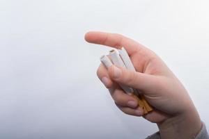 Hand is holding bundle of cigarettes on white photo