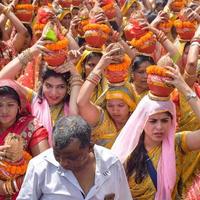 nueva delhi, india 03 de abril de 2022 - mujeres con kalash en la cabeza durante el templo jagannath mangal kalash yatra, devotos hindúes indios llevan ollas de barro que contienen agua sagrada con un coco encima foto