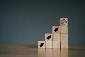 Pile of wooden cube block stack as stair step on wood table. Success, climbing to the top, Progression, business growth concept. photo