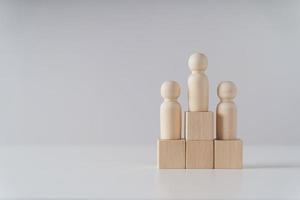 wooden figures peg doll standing on the podium of wooden cube blocks with copy space. ranking and strategy concept. photo