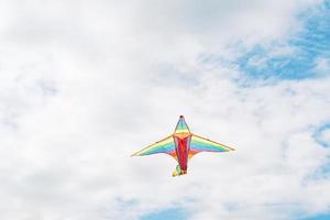 cometa en mano en el cielo azul con tiempo soleado y viento. cometa volando en verano con espacio de copia. libertad. juegos de verano y diversion foto