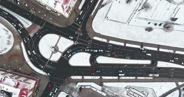 vista aérea acelerada de video 4x arriba en el cruce de carreteras de invierno con tráfico pesado en la ciudad con nieve