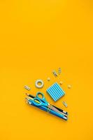 Yellow background with scissors and pencils for school advertising. photo