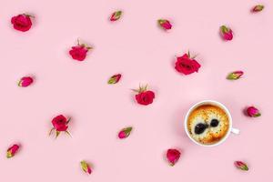 taza de café de la mañana y hermosas rosas sobre fondo rosa, vista superior. foto