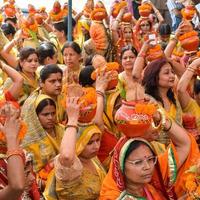 nueva delhi, india 03 de abril de 2022 - mujeres con kalash en la cabeza durante el templo jagannath mangal kalash yatra, devotos hindúes indios llevan ollas de barro que contienen agua sagrada con un coco encima foto