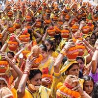 New Delhi, India April 03 2022 - Women with Kalash on head during Jagannath Temple Mangal Kalash Yatra, Indian Hindu devotees carry earthen pots containing sacred water with a coconut on top photo