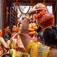 nueva delhi, india 03 de abril de 2022 - mujeres con kalash en la cabeza durante el templo jagannath mangal kalash yatra, devotos hindúes indios llevan ollas de barro que contienen agua sagrada con un coco encima foto