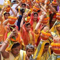 nueva delhi, india 03 de abril de 2022 - mujeres con kalash en la cabeza durante el templo jagannath mangal kalash yatra, devotos hindúes indios llevan ollas de barro que contienen agua sagrada con un coco encima foto